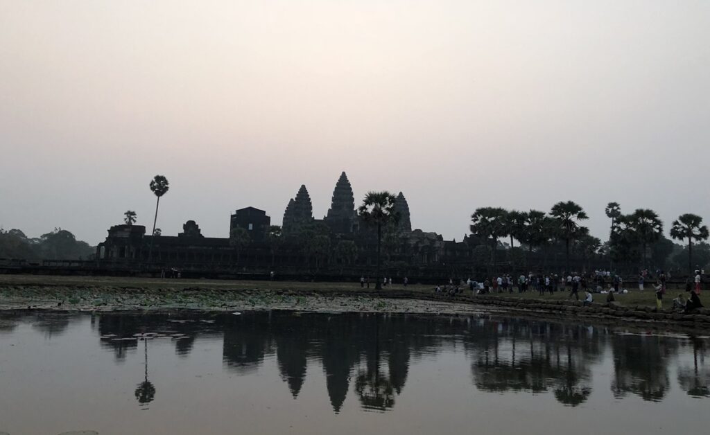 早朝のアンコール・ワットと寺院のシルエットが水面に映る風景