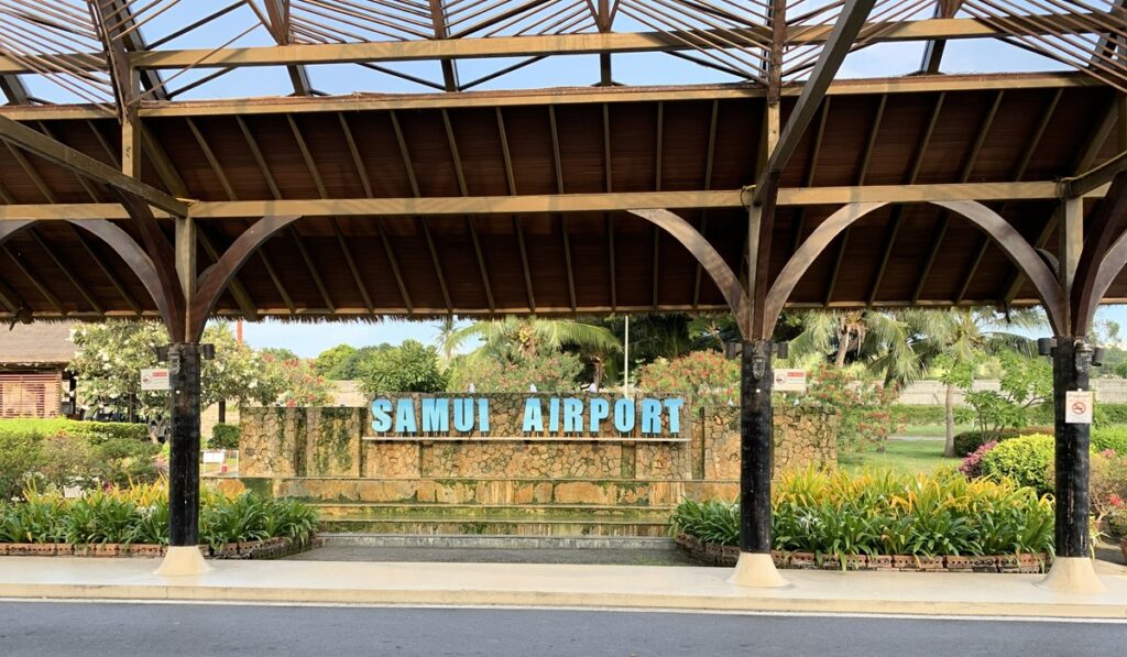 木造の開放的な屋根の下にSAMUI AIRPORTの看板がある南国らしいサムイ空港の風景