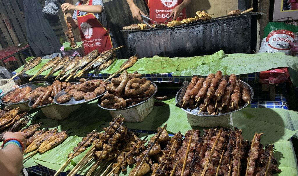 ルアンパバーンのナイトマーケットで魚や肉、ソーセージを串焼きにして販売する屋台