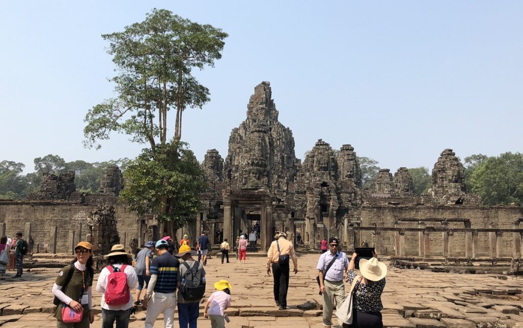 アンコール・トムの中心にあるバイヨン寺院と遺跡を見学する観光客