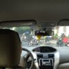 フロントガラス越しに、道路を走る多くのバイクや街路樹、建物が見え、ベトナム特有の交通風景が見える